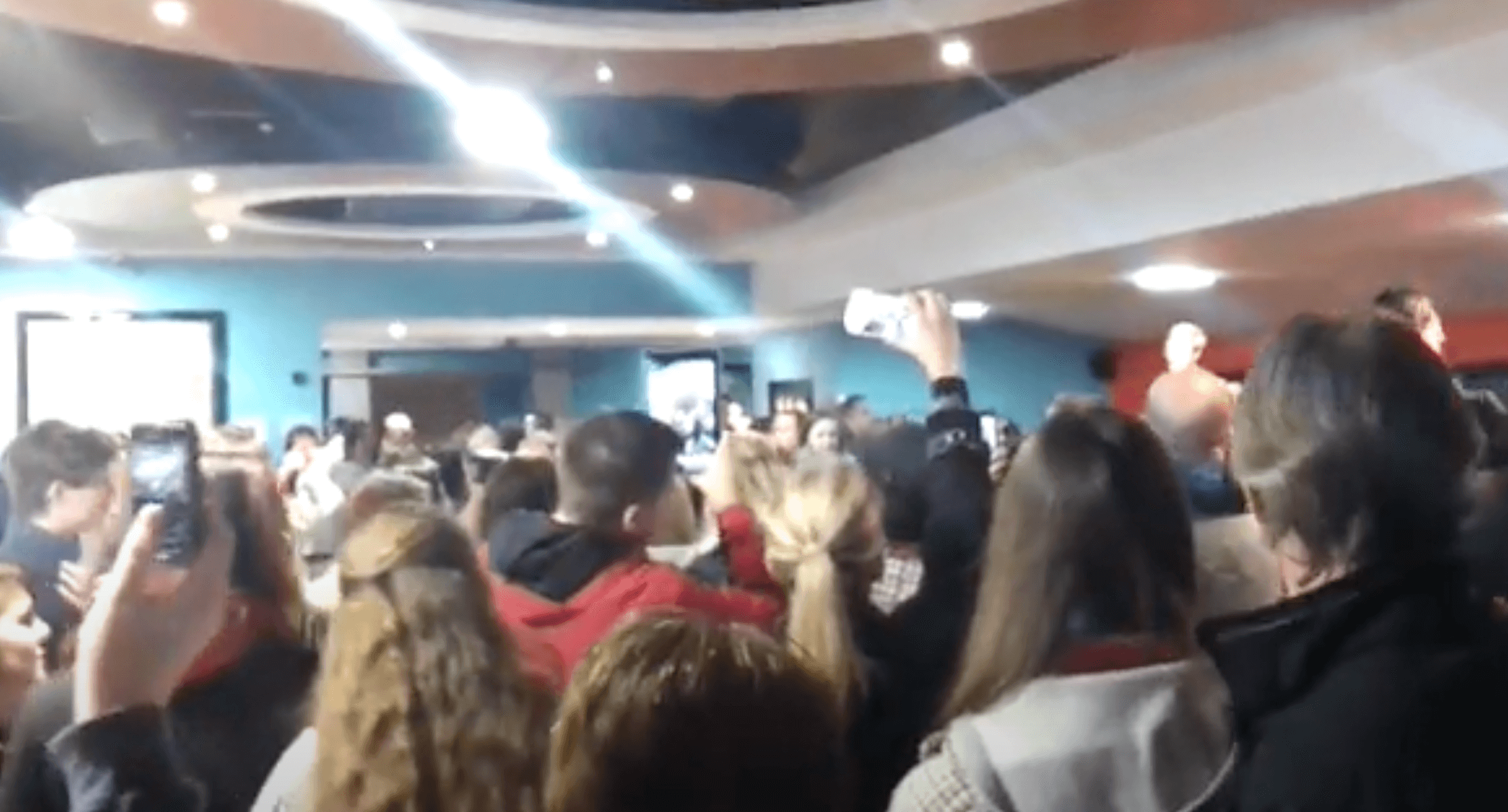 a group of people singing in a cinema foyer