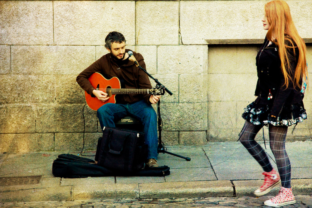 A busker playing the guitar