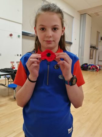 A member of 2nd Fairwater Guides with the poppy she knitted
