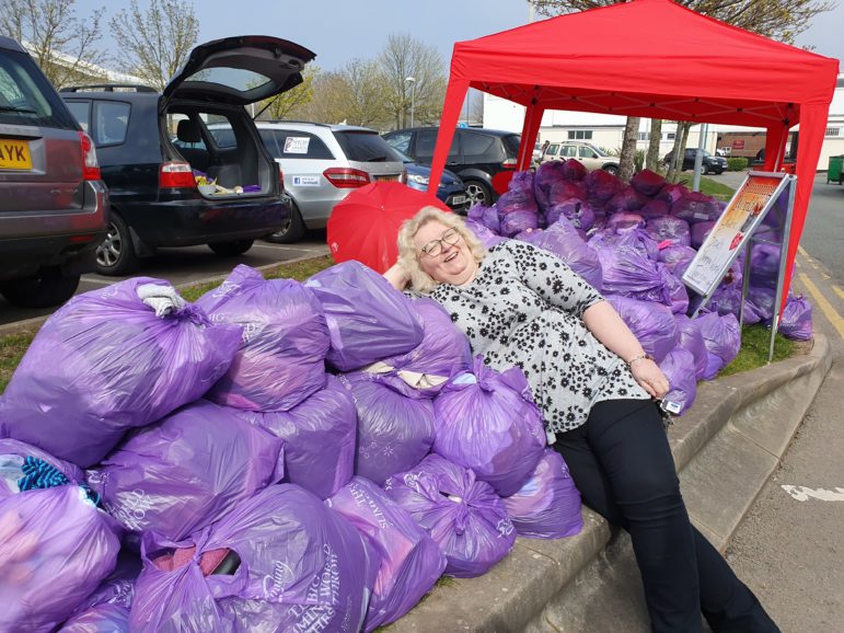 A volunteer takes a rest from collecting donations of oversized clothes