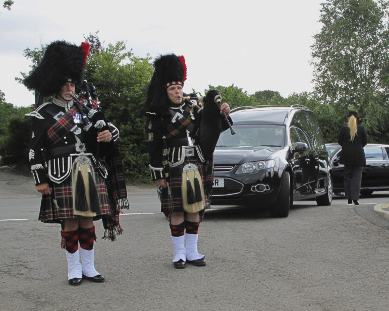 Pipers lead a funeral cortege