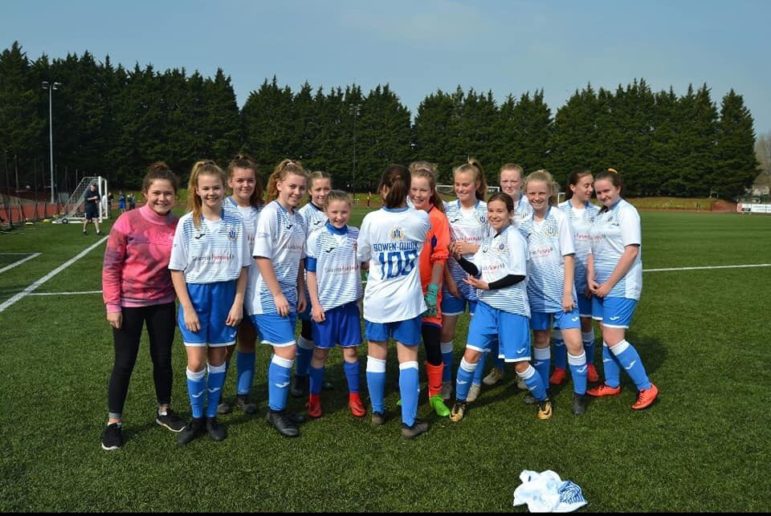 Summer Bowen-Quirk and her teammates celebrate her 100th goal for Coed Eva