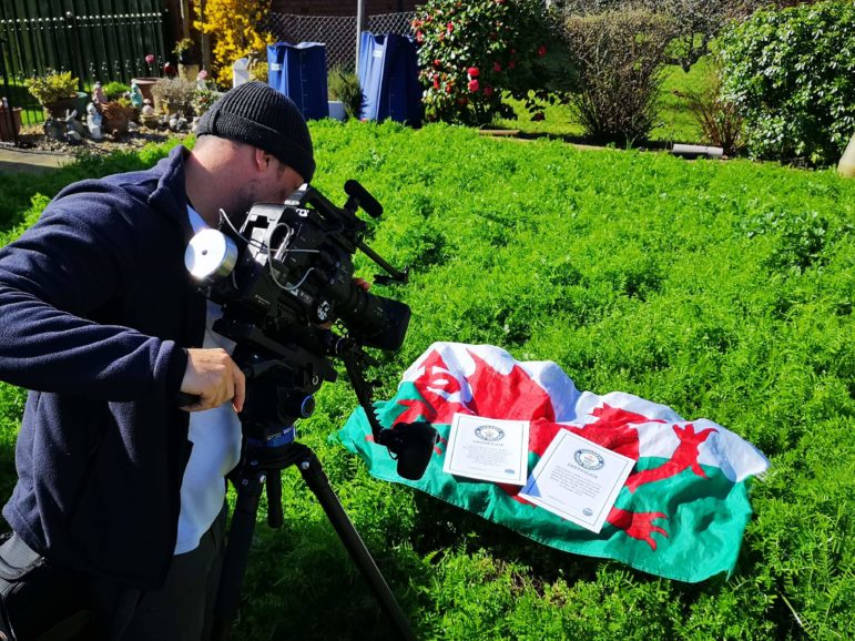 A cameraman filming a shot of a Wales flag