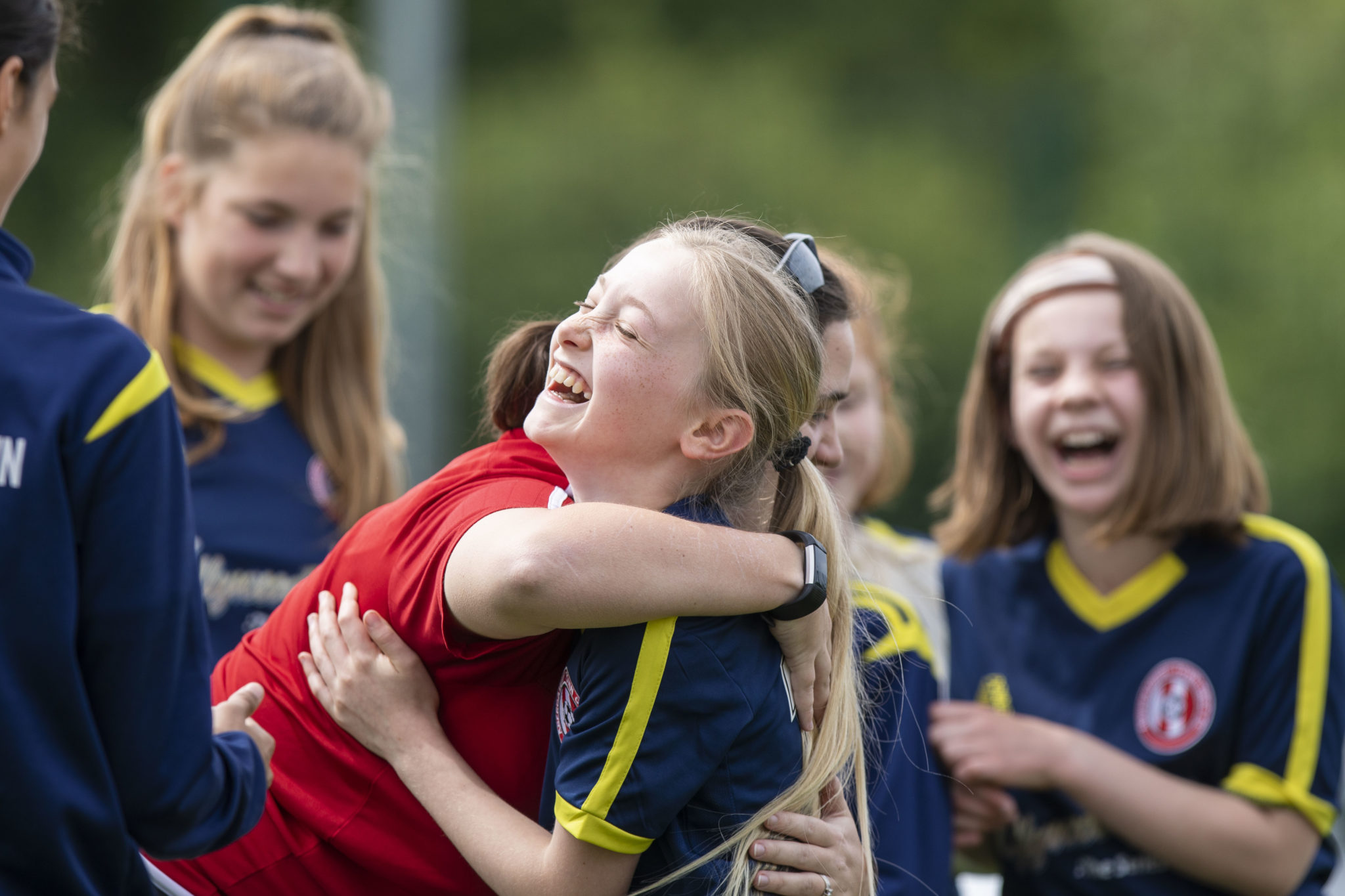 A footballer laughing with her team mates