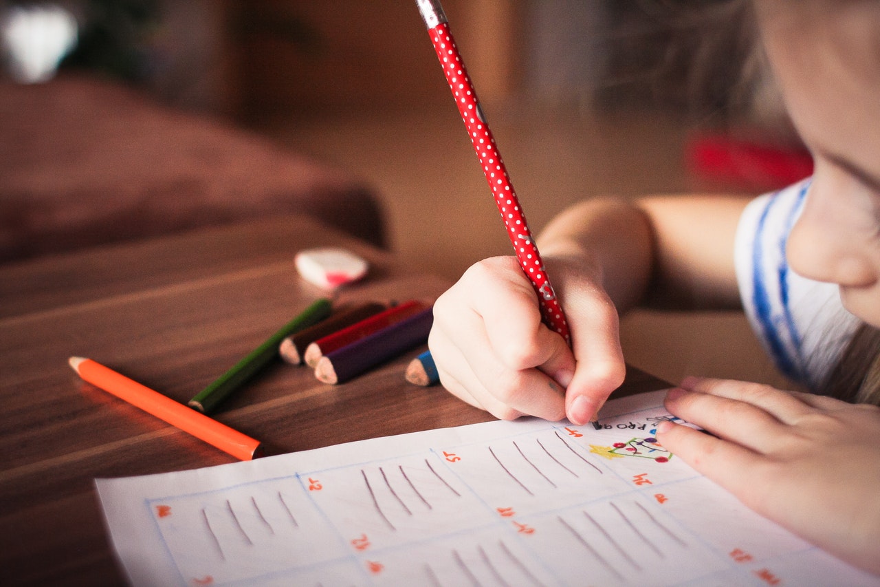 Close up of girl writing (photo from Pexels)