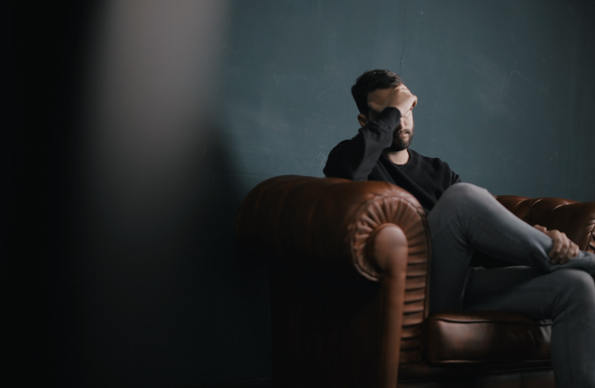 A man covering face with hand