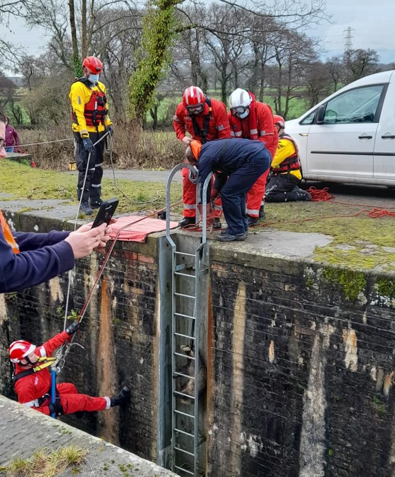 Rescuers abseiling down the lock wall