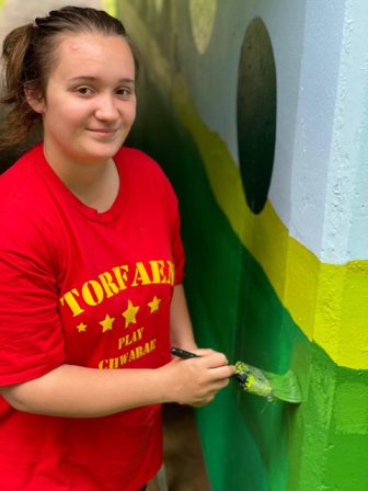 A woman painting a subway wall