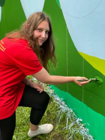 A woman painting a wall