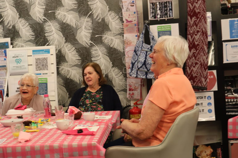 Three women laughing at a table