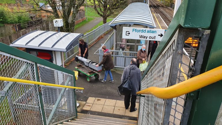 Two men wheeling a train on a trolley