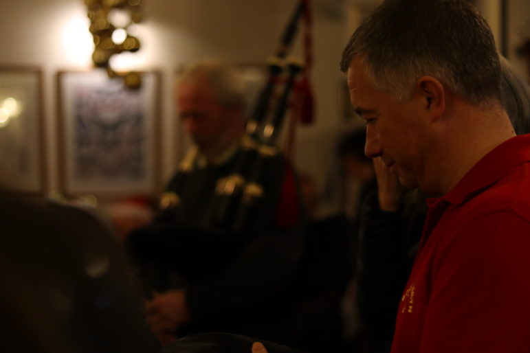 a man listening to a bagpiper