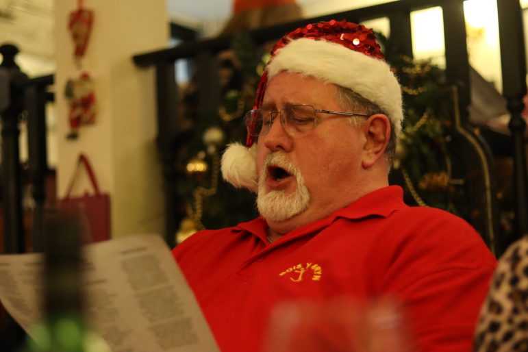 a man singing in a santa hat