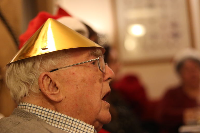 a man singing in a christmas hat