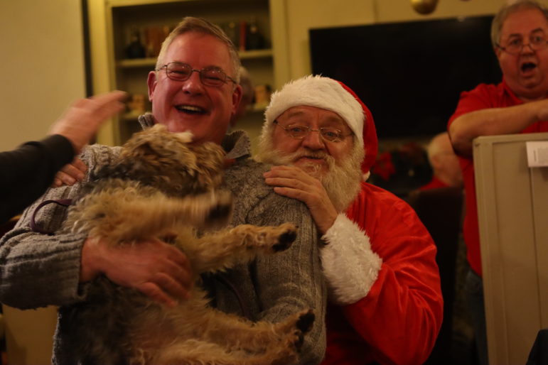 a man and a dog on santa's lap