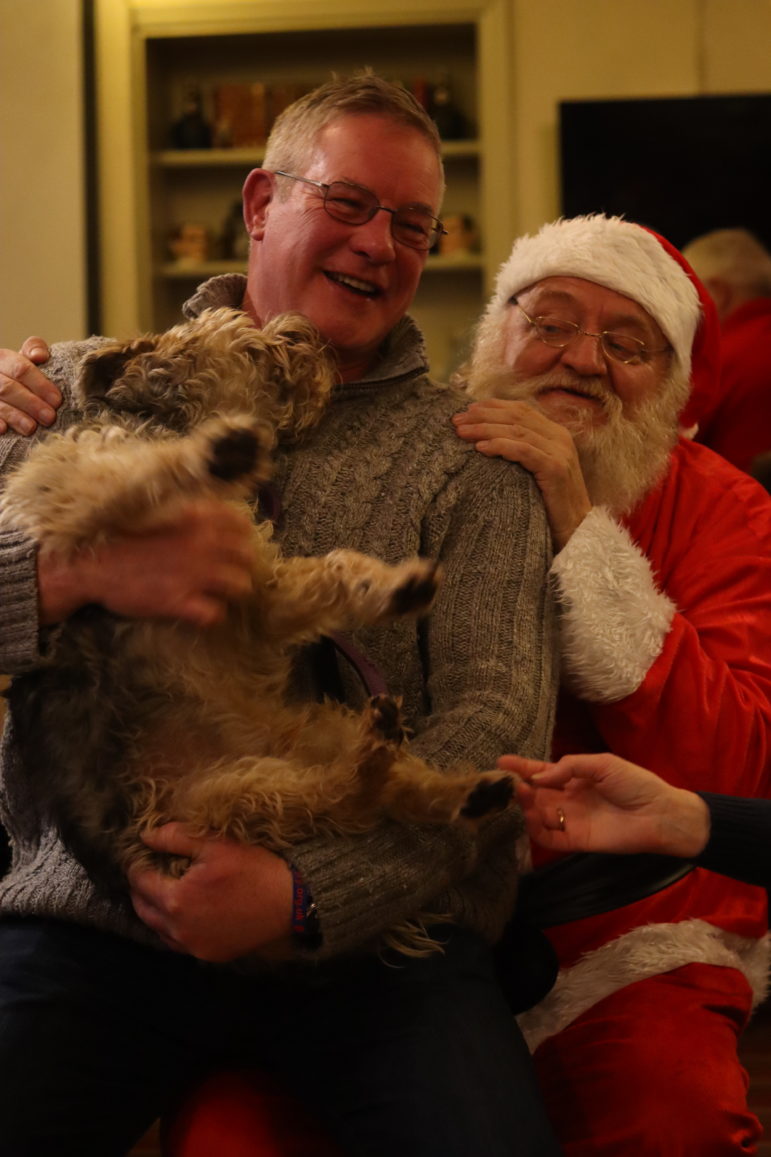 a man and a dog on santa's lap