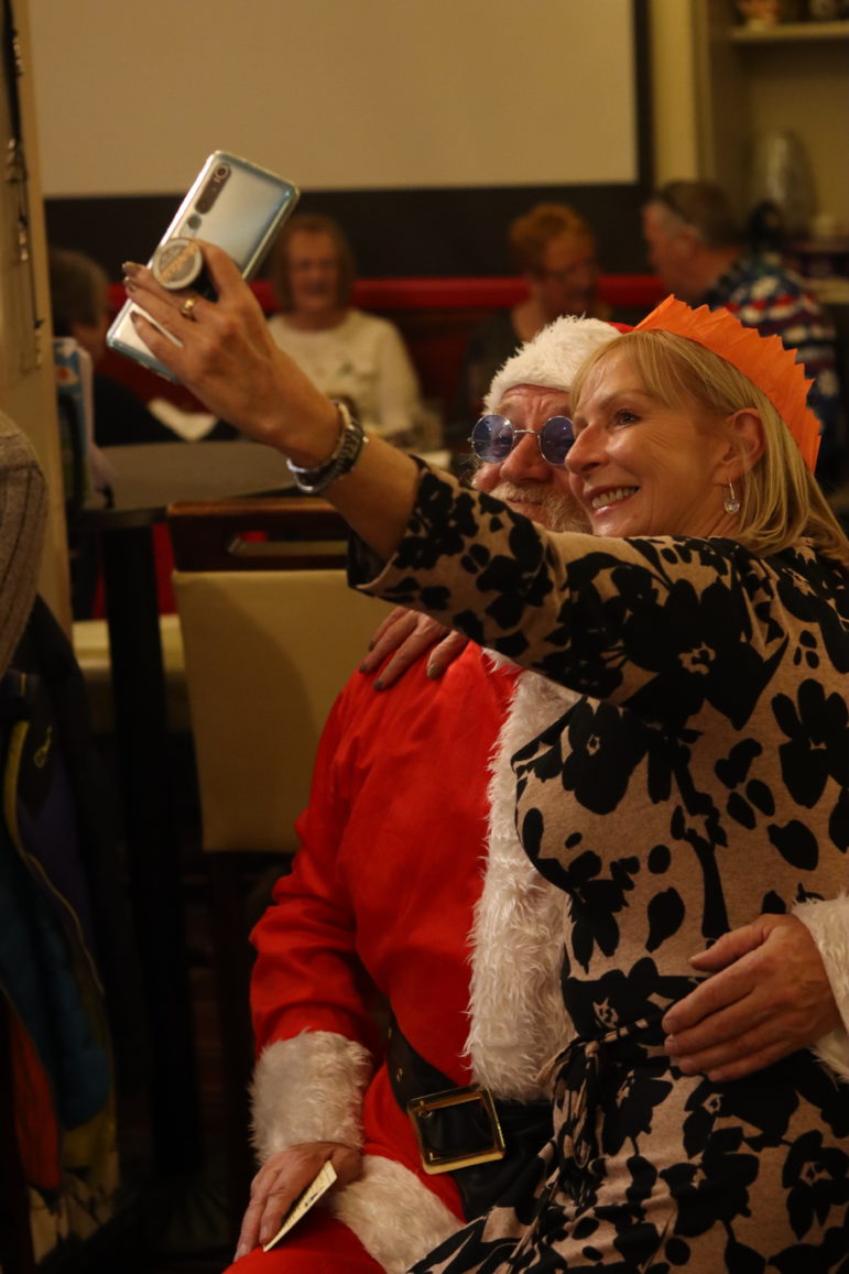 a woman having a selfie with santa