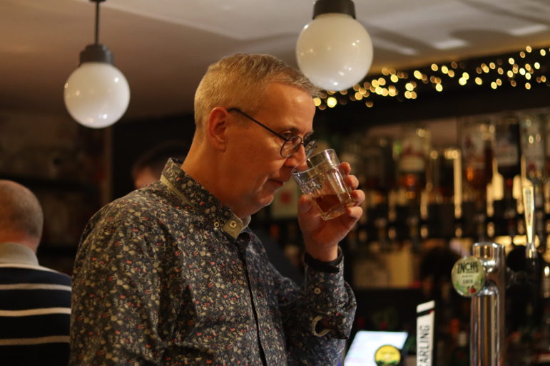 a man sniffing drink