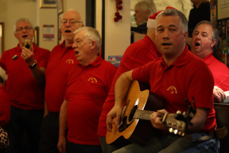 a man on guitar with men singing