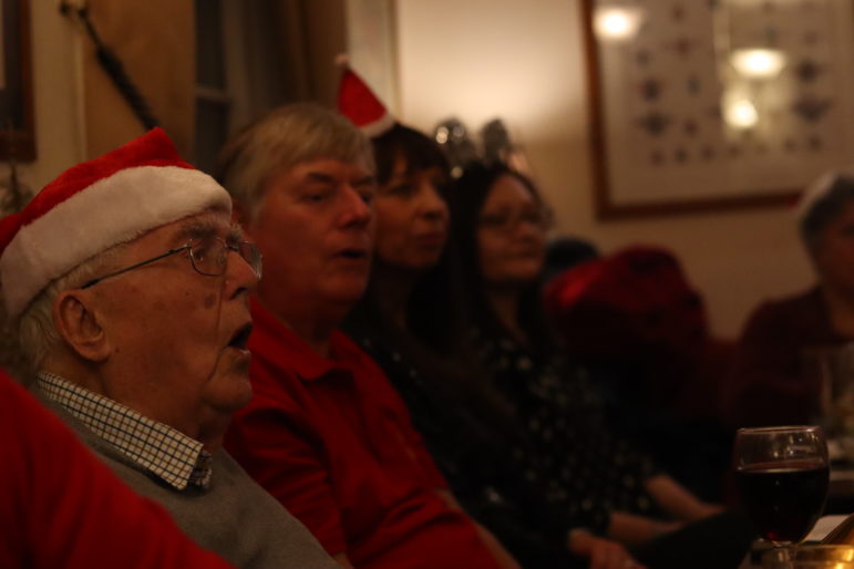 a man singing in a santa hat