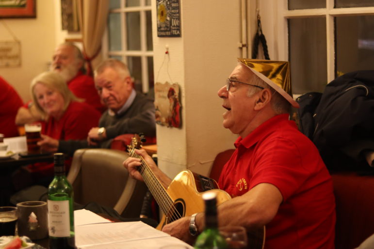 a man in christmas hat playing guitar