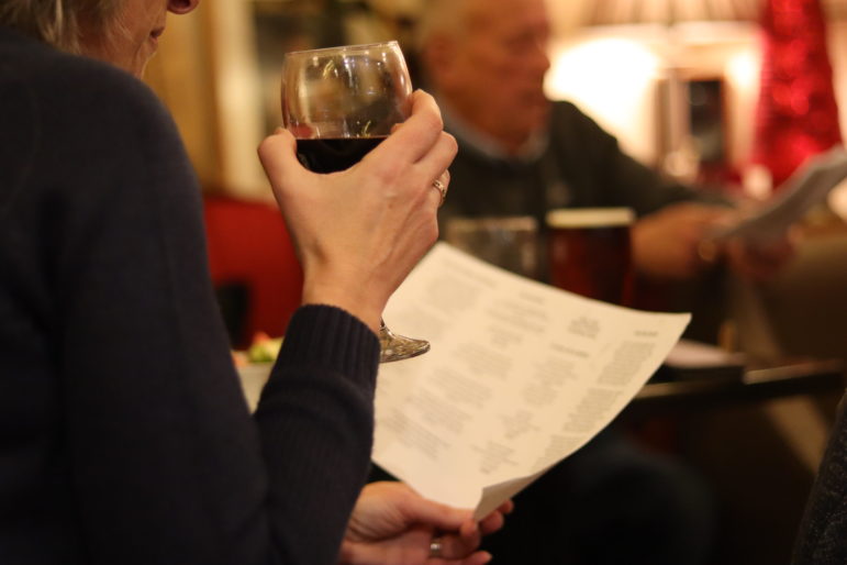 a woman's hand holding a glass of red wine