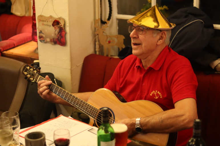 man on guitar in christmas hat