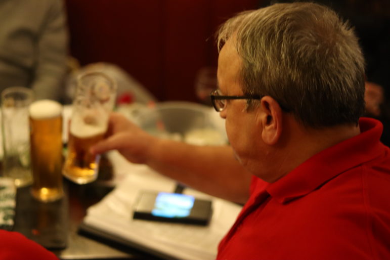 man grabs pint of beer