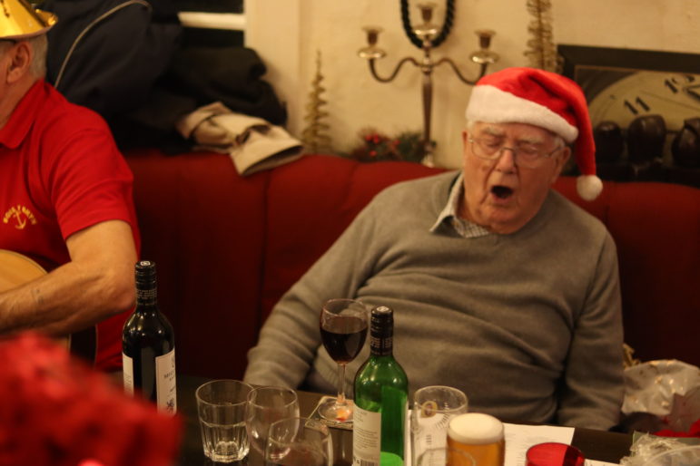 man in santa hat singing