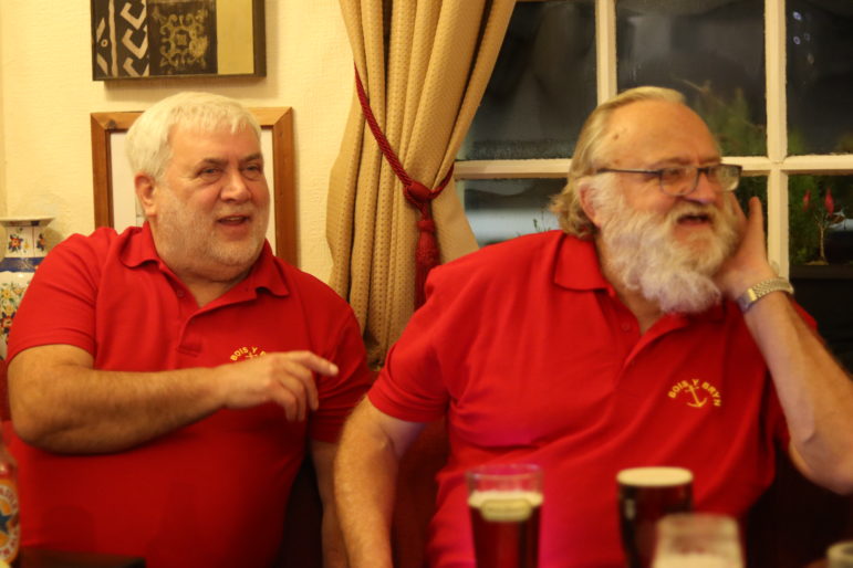 two men in red polo shirts in pub