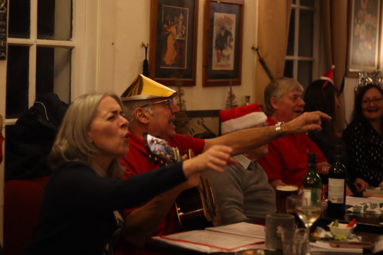 man and woman wave hands in air while singing