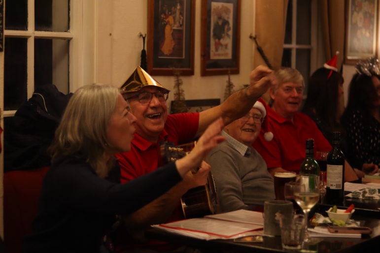 a man and woman waving hands in air and singing