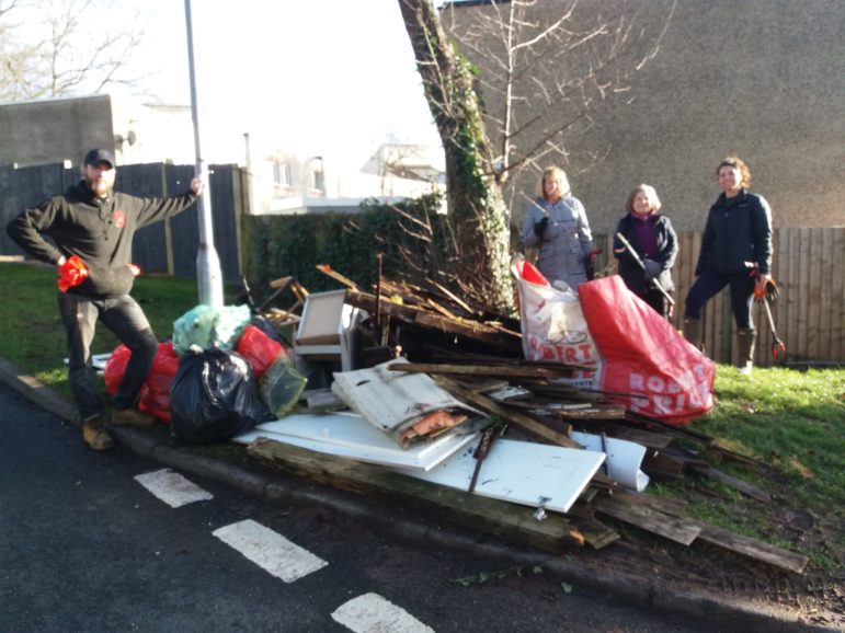 People stood by a pile of rubbish