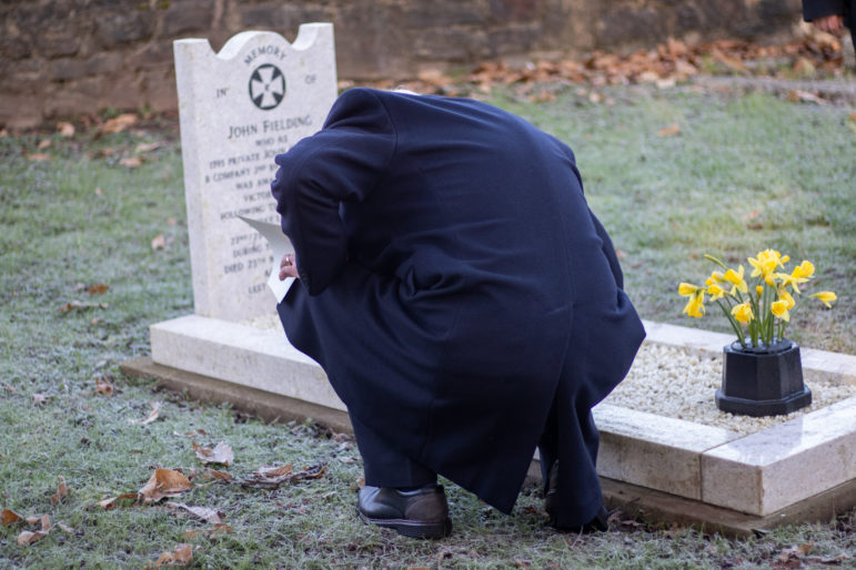 A man kneeling by a grave