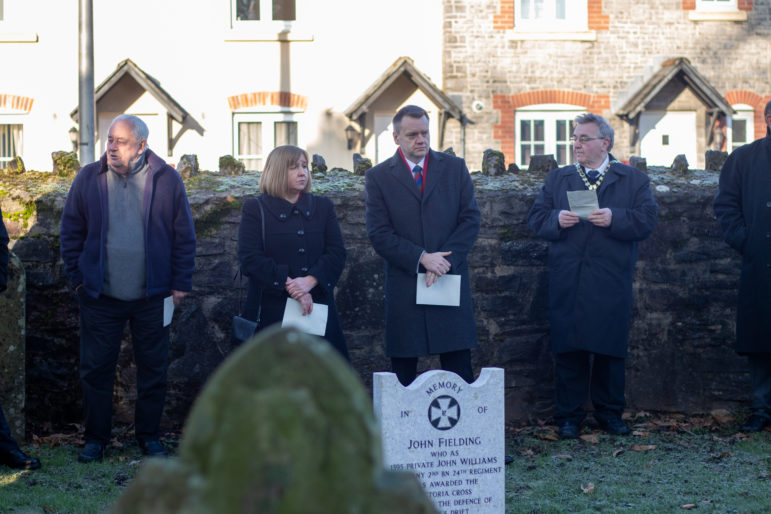 People stood by a grave