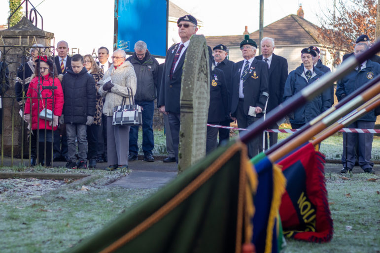 A former serviceman stood by a grave