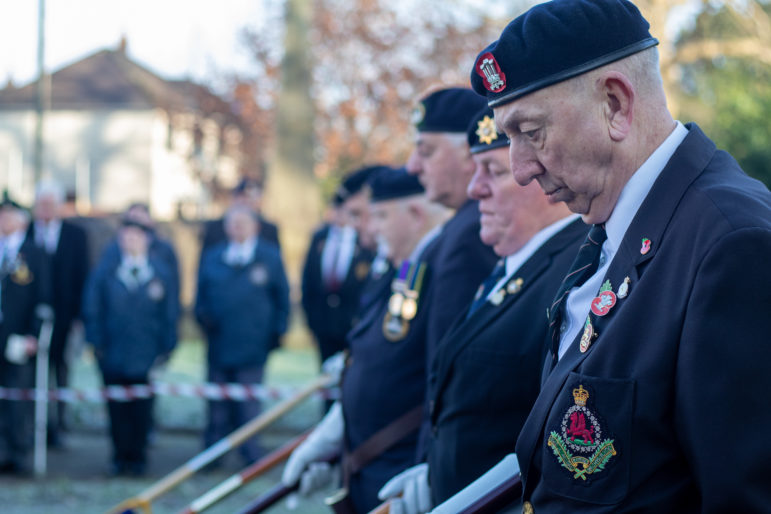 Former servicemen lower their flags