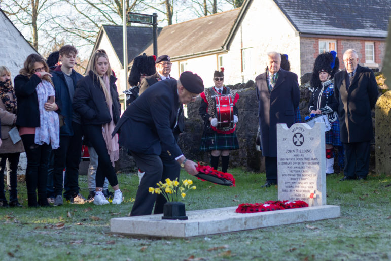 A man lays a wreath