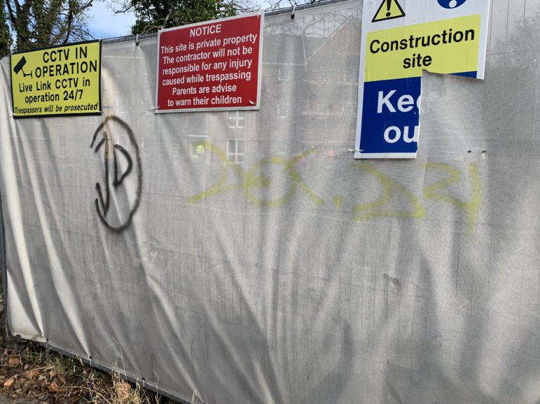 A vandalised building site hoarding