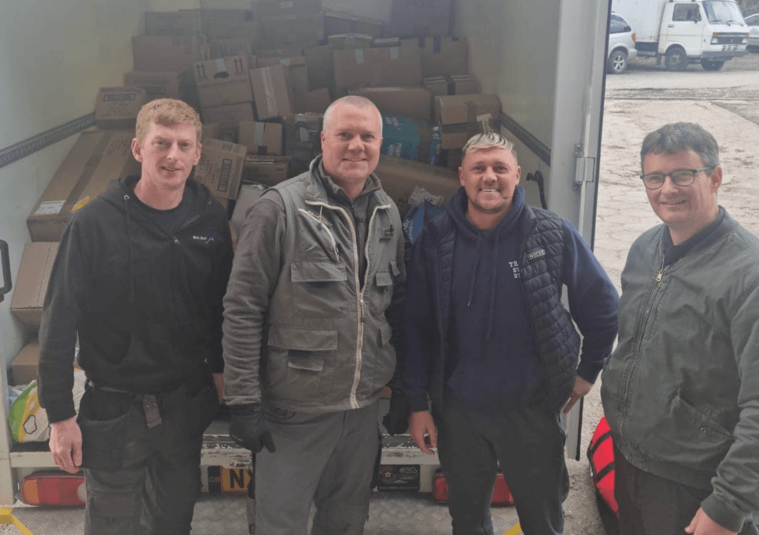 four men stood at back of a van