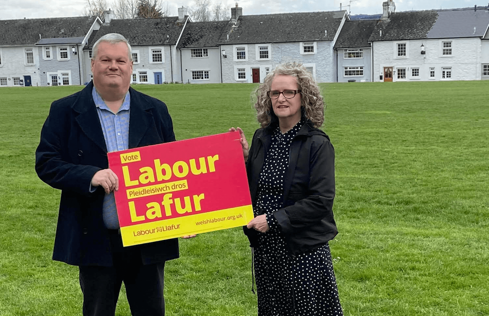 two candidates hold a Labour placard