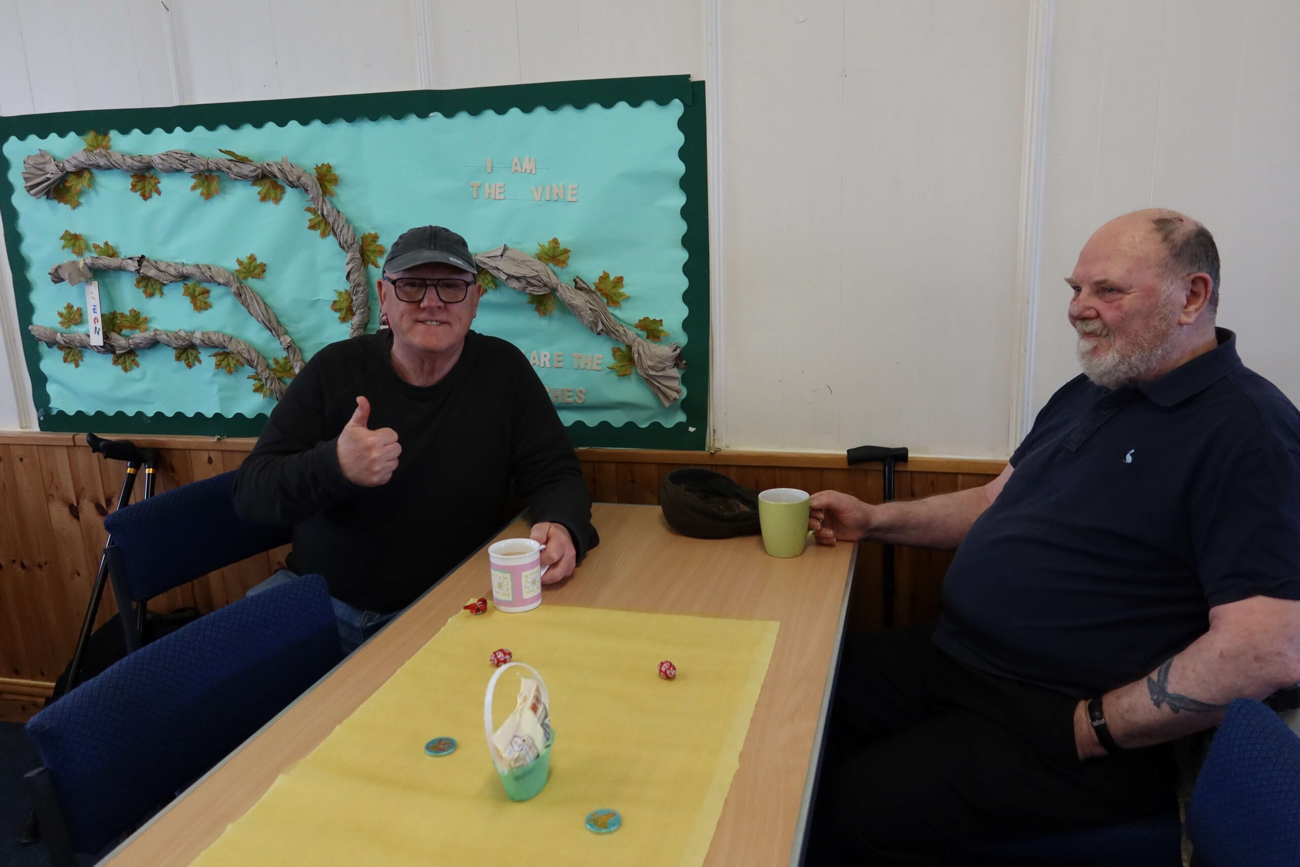 two men with cups of tea