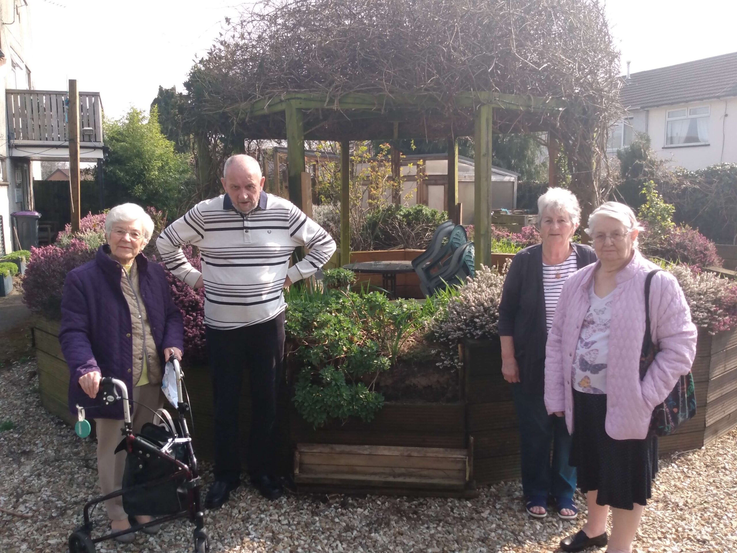 Four people stood by a pergola