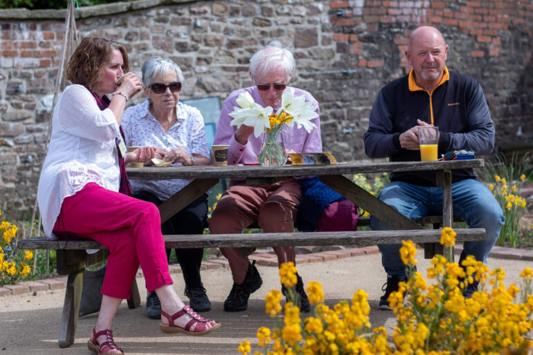 four people sat at bench with drinks