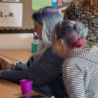 two women look at ipad