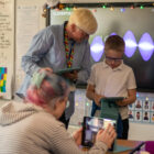 boy on ipad as woman looks on