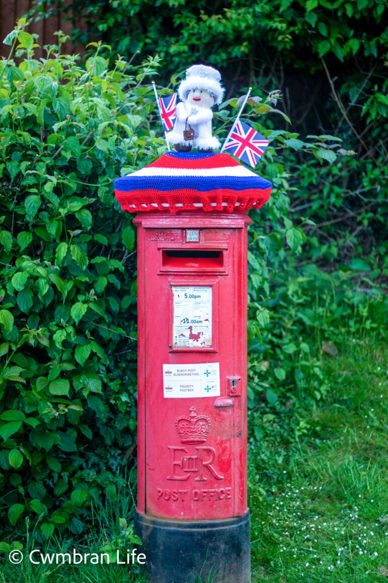 A knitted Queen on top of postbox