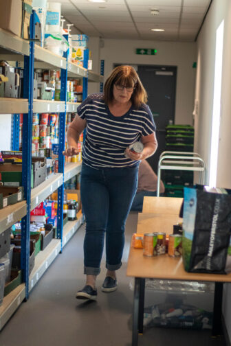 woman walking holding a tin