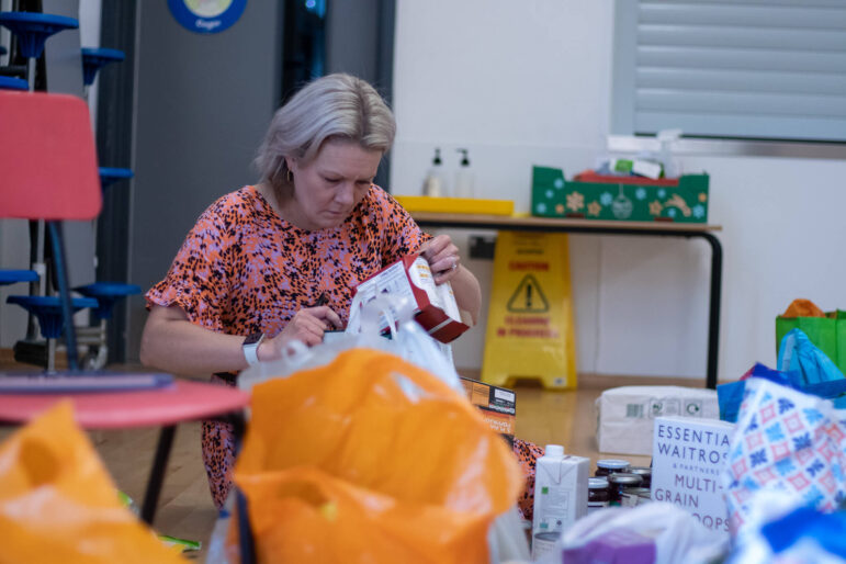 woman puts pack of food in bag