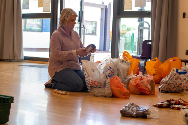 woman puts pack of food in bag